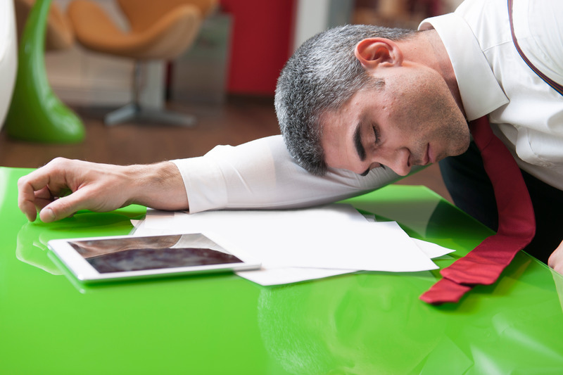 Businessman asleep on documents