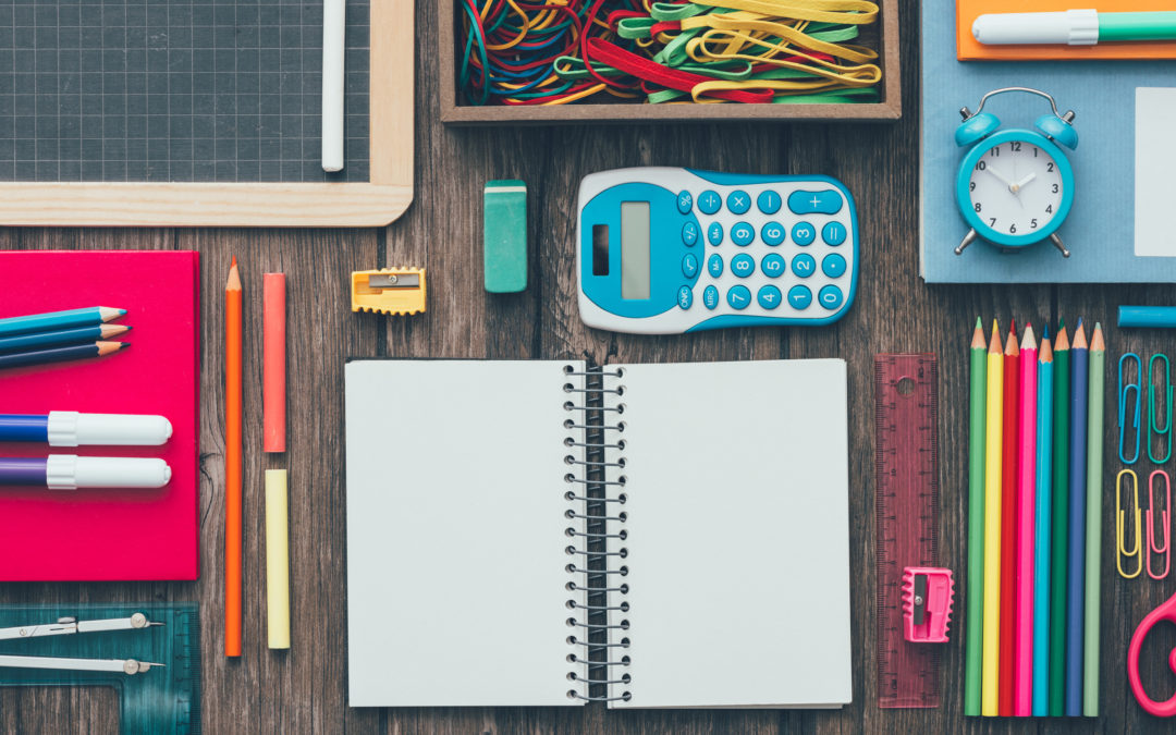 Colorful pencils and stationery on a school desk and open blank notebook, back to school concept, flat lay