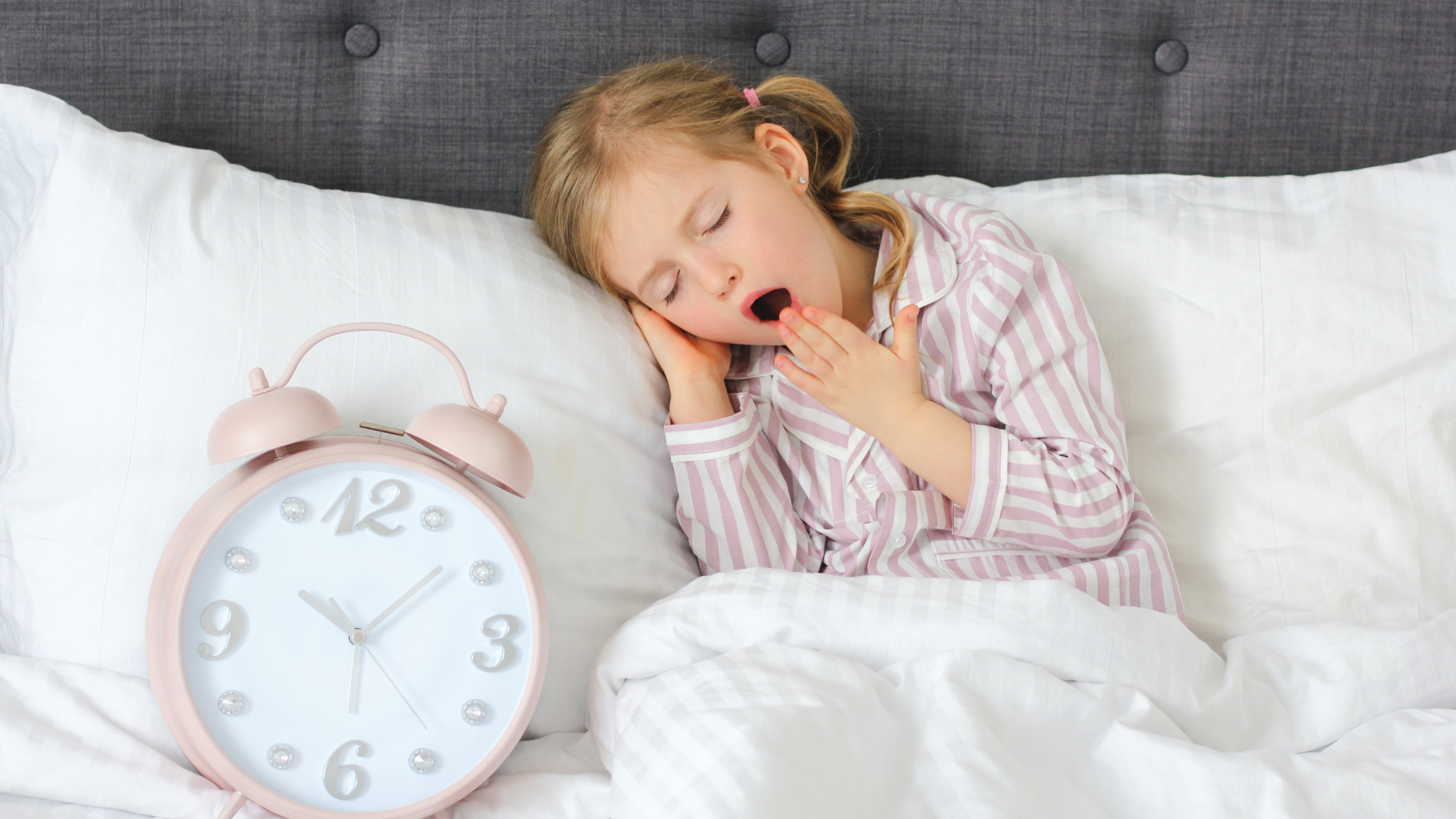 girl in bed with clock