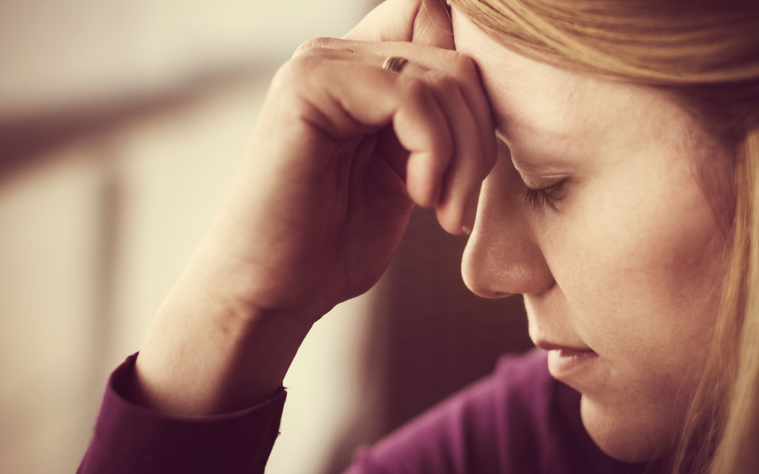 woman with hand on head and eyes closed