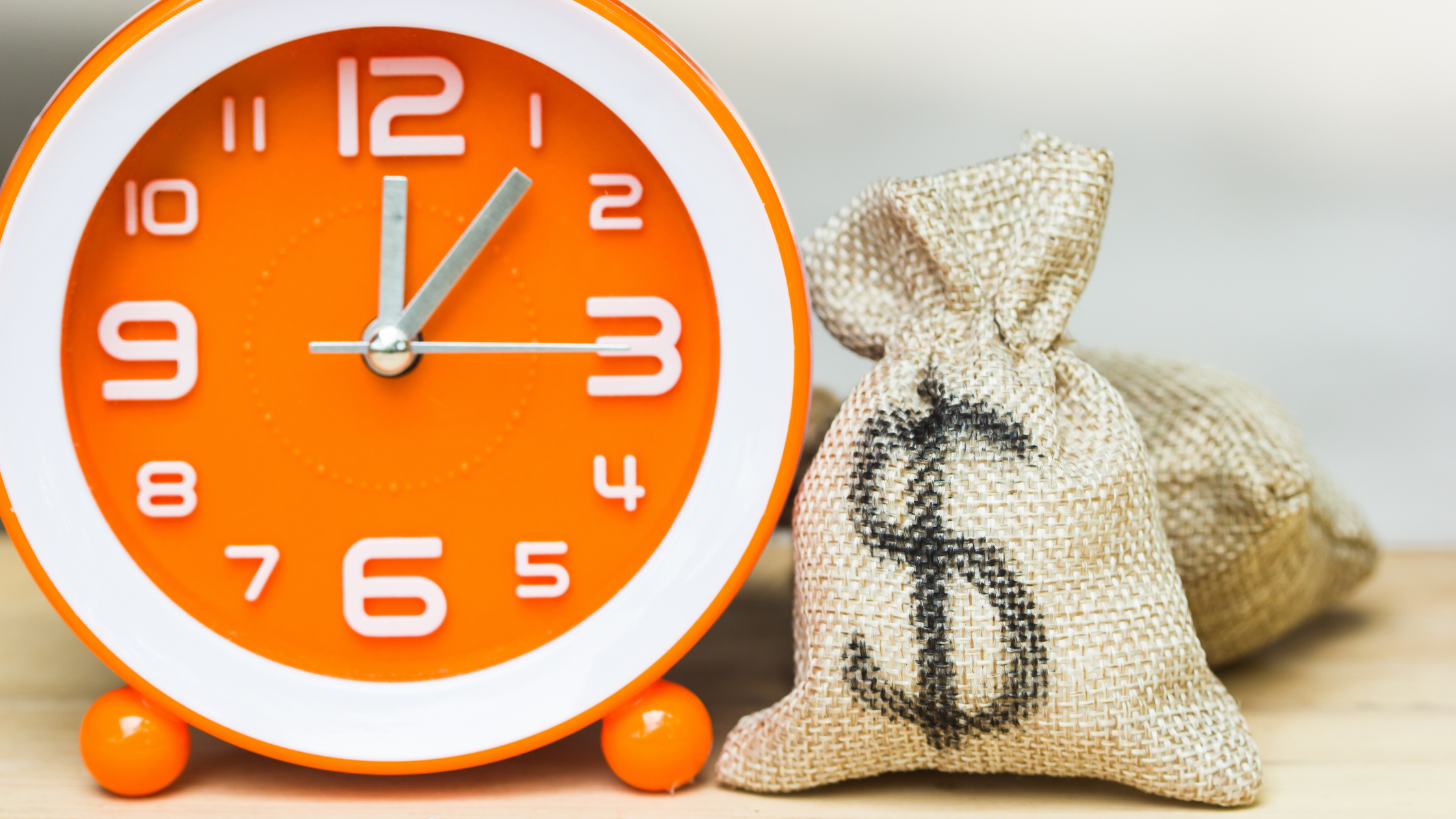 large orange clock and back with dollar sign on it close up