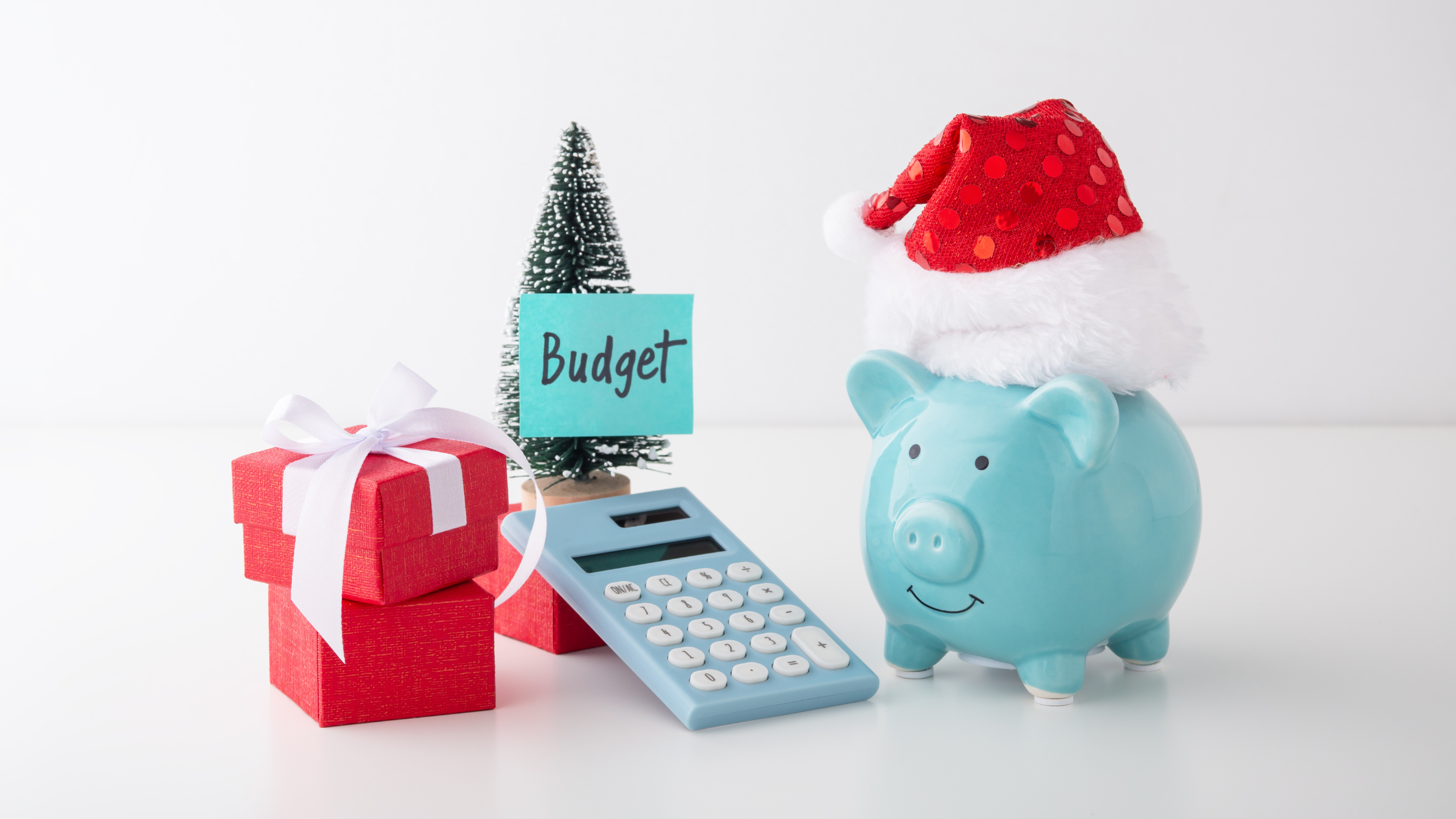 small presents xmas tree calculator piggy bank with santa hat and a postit that says budget